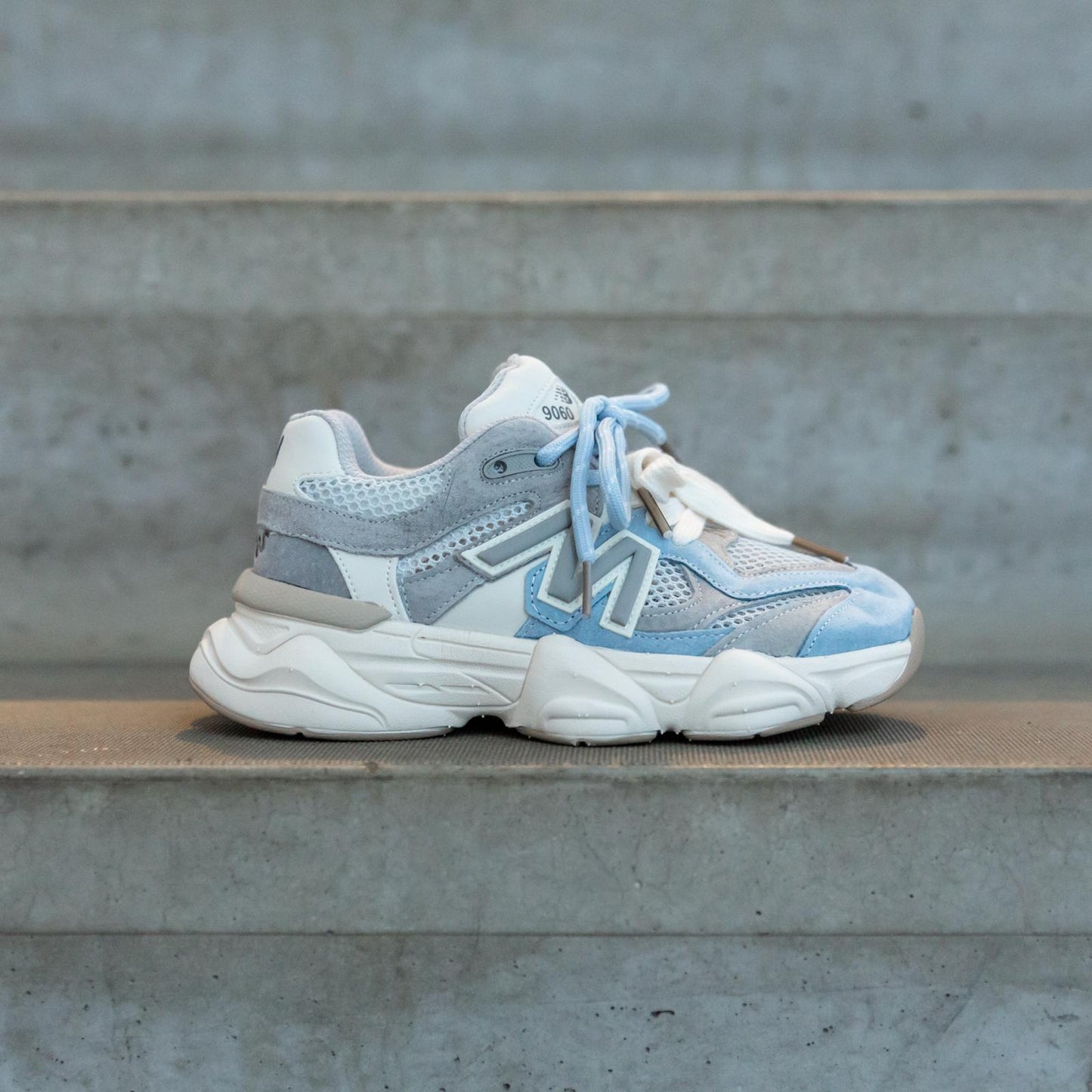 Zijaanzicht van de Styloz Blue Steel kindersneakers op betonnen trap in stedelijke omgeving